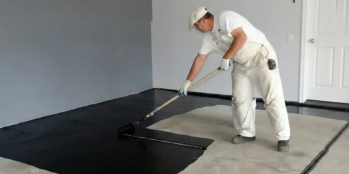 basement waterproofing professional applying waterproof coating to protect a basement floor in Orange, CA